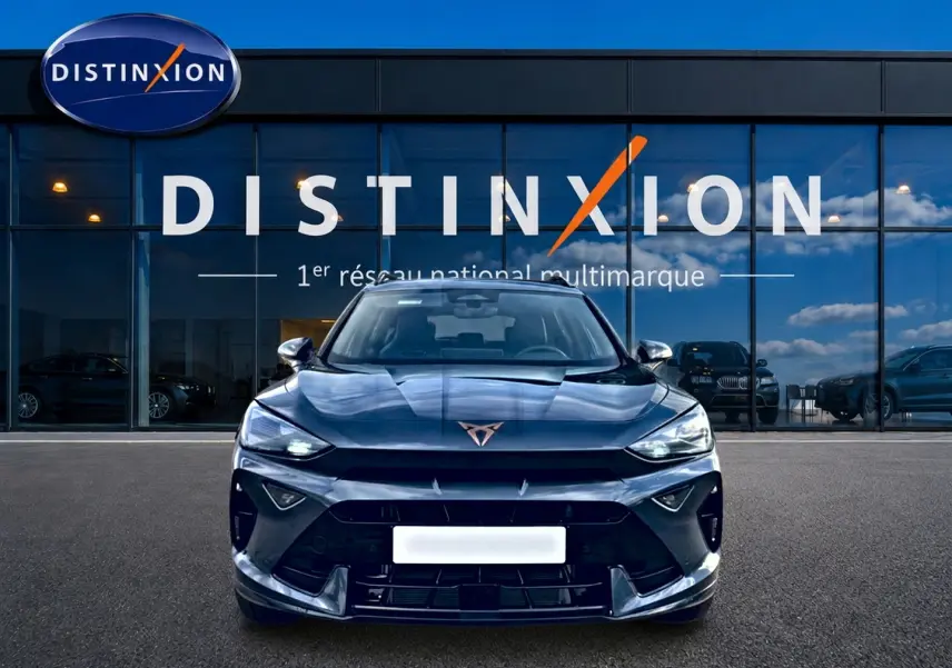 Vue frontale d'un CUPRA Formentor gris magnétique 2026 avec calandre sportive et logo distinctif sur fond de vitrine Distinxion.