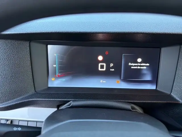 Gros plan sur l'écran numérique du tableau de bord du Citroën Jumpy noir, affichant la vitesse et alertes.
