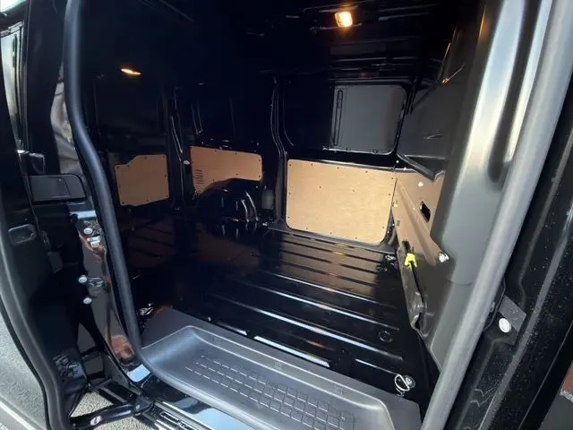 Vue intérieure du compartiment de chargement noir du Citroën Jumpy FG M 2.2 Diesel, avec porte latérale ouverte.