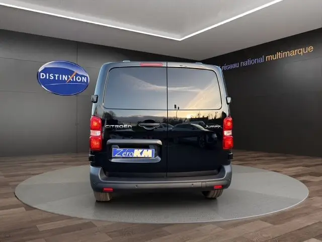 Vue arrière d’un Citroën Jumpy noir avec double portes arrière fermées dans un showroom lumineux.