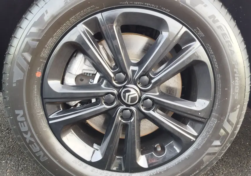 Gros plan sur la jante noire brillante avec logo Citroën, montée sur un pneu Nexen N'Fera Primus.