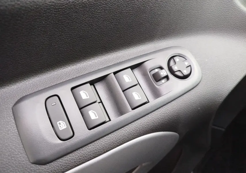 Gros plan sur les commandes de lève-vitres et rétroviseurs côté gauche du Citroën Berlingo 2025 en Kaolin White.