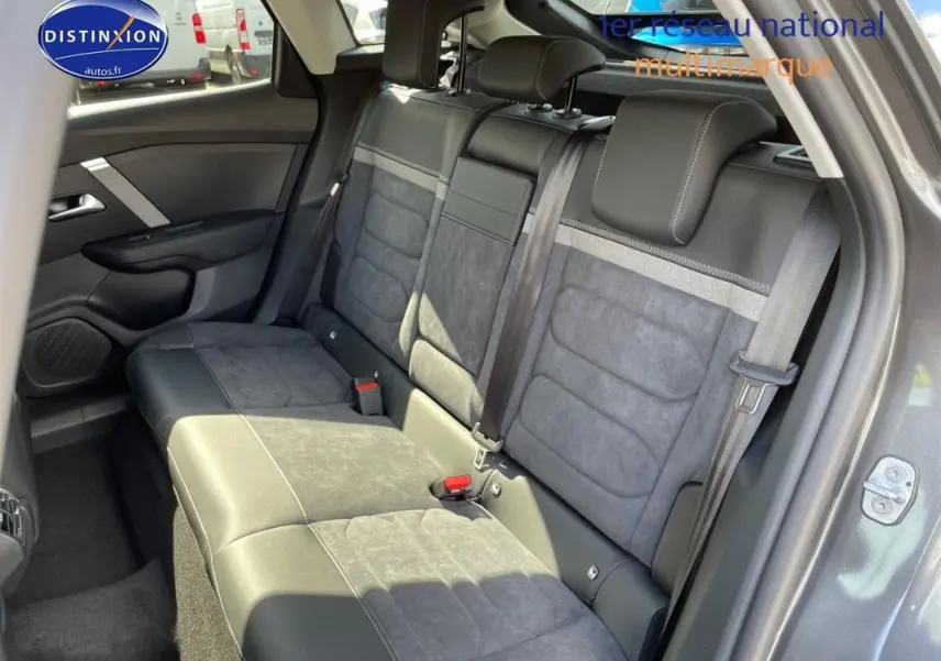 Vue intérieure côté gauche des sièges arrière en tissu et cuir gris sur Citroën C4 platine 2024 avec ceinture de sécurité visible.