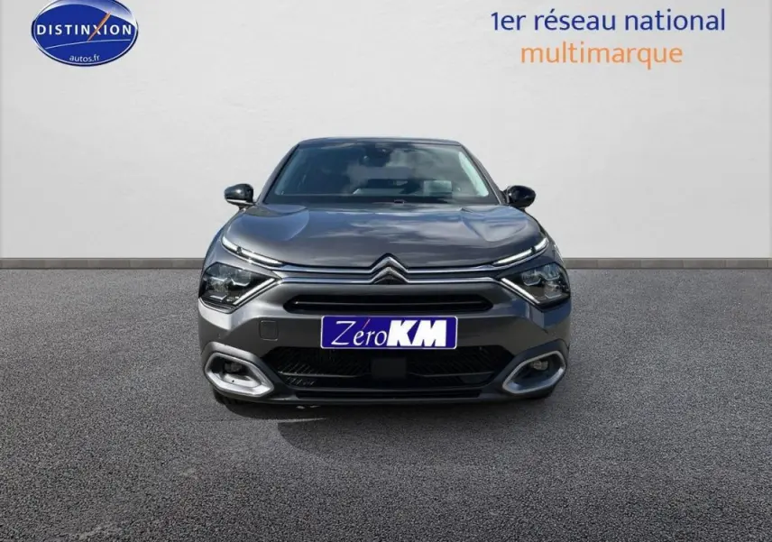 Vue frontale d'une Citroën C4 platine 2024 avec feux LED et calandre distinctive, sur sol gris neutre.