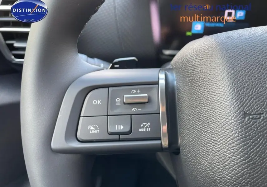 Gros plan sur les commandes au volant cuir noir de la Citroën C4 platine 2024 avec régulateur et assistant de conduite.