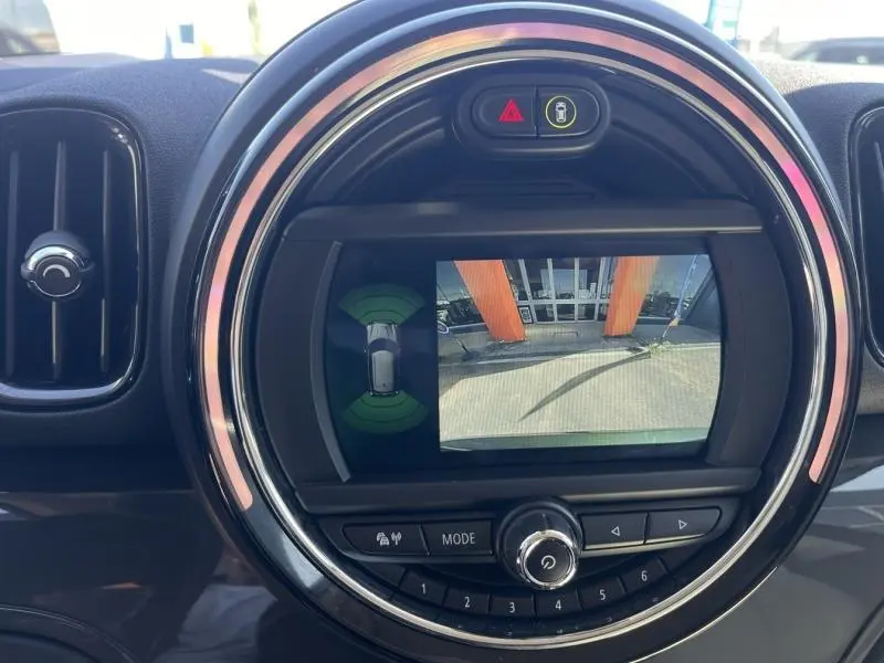 Vue rapprochée de l'écran central rond du MINI Countryman affichant la caméra de recul avec cadre noir et détails chromés.