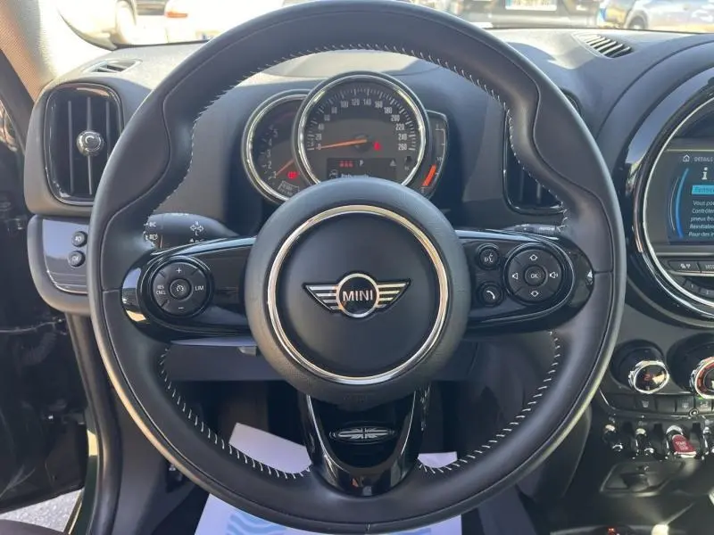 Vue rapprochée du volant cuir multifonction noir d'une MINI Countryman Cooper D 2018 avec tableau de bord et écran central visibles.