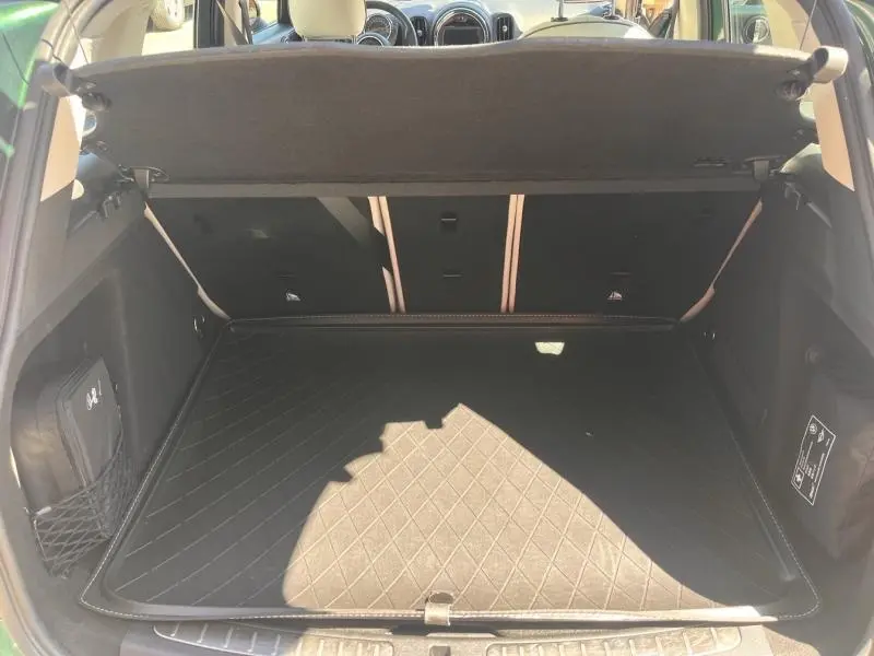 Vue du coffre ouvert du MINI Countryman Cooper D 2018, montrant un espace de chargement propre avec tapis matelassé noir.