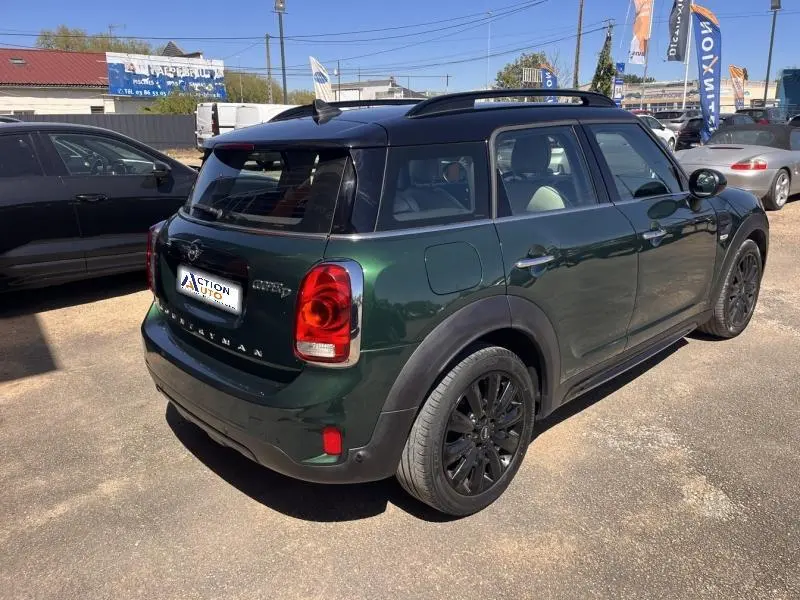Vue 3/4 arrière droite d'une MINI Countryman 2018 British Racing Green avec toit noir et jantes noires.