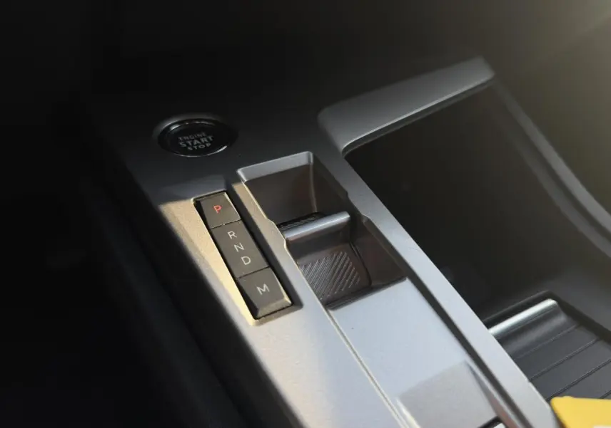 Gros plan sur la console centrale de la Peugeot 308 2025, montrant la commande de boîte auto et le bouton start/stop.