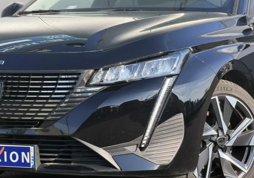 Gros plan 3/4 avant droit d’une Peugeot 308 noire Perla avec feux LED et jante alliage 17 pouces.
