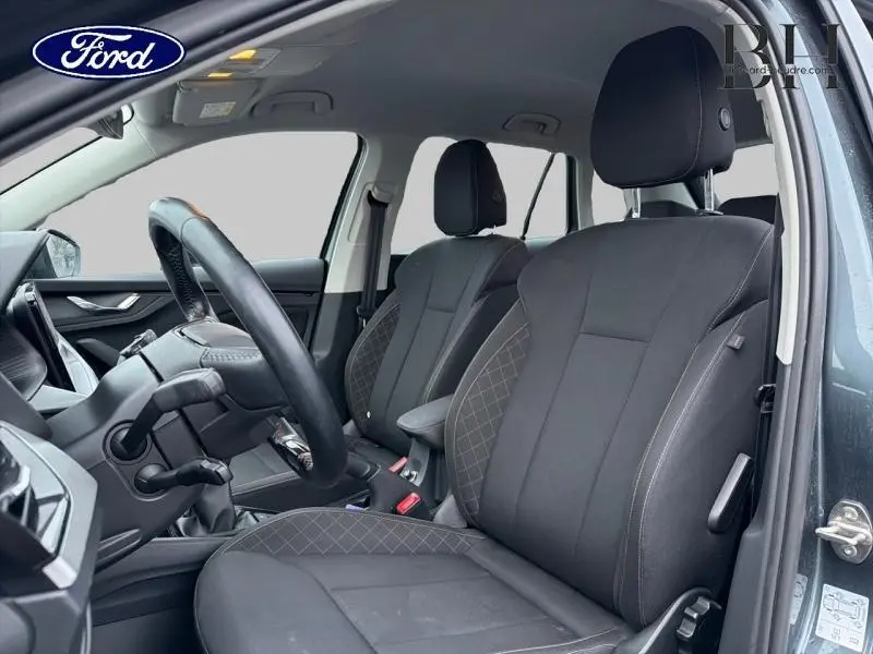 Vue intérieure côté conducteur du Skoda Kamiq gris météore 2021, sièges tissu noir avec surpiqûres grises.