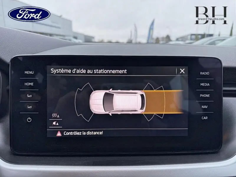 Affichage du système d'aide au stationnement sur écran tactile intérieur d'une Skoda Kamiq gris Météore, vue de face.