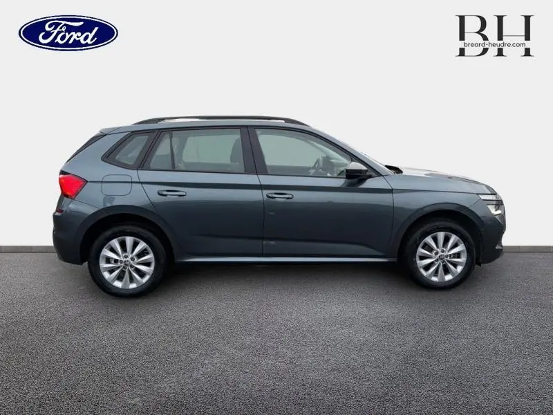 Profil droit d'un Skoda Kamiq 1.0 TSI 95ch Business gris Météore avec jantes alu et toit noir.