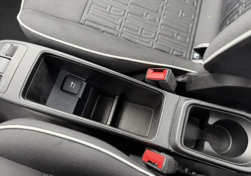Vue rapprochée de la console centrale et des sièges noirs avec surpiqûres blanches du Fiat 500 électrique 2024.