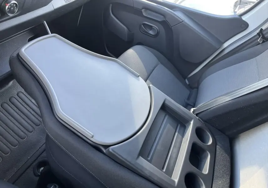 Vue intérieure côté passager du Renault Master blanc 2021, avec tablette rabattable et porte-gobelets intégrés.