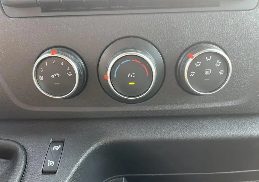 Commandes de climatisation du Renault Master 2021 en gros plan, avec réglages de ventilation et température sur fond noir.