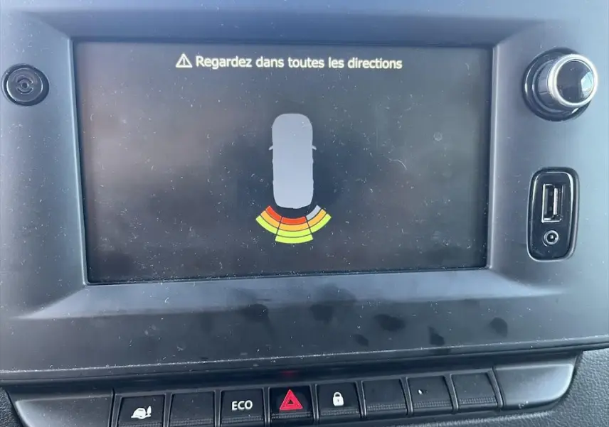 Écran central du tableau de bord du Renault Master 2021 affichant l'alerte de proximité avec boutons de commande en dessous.