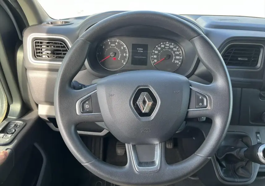 Vue rapprochée du volant noir et du tableau de bord du Renault Master 2.3 DCI 135, avec commandes intégrées au volant.