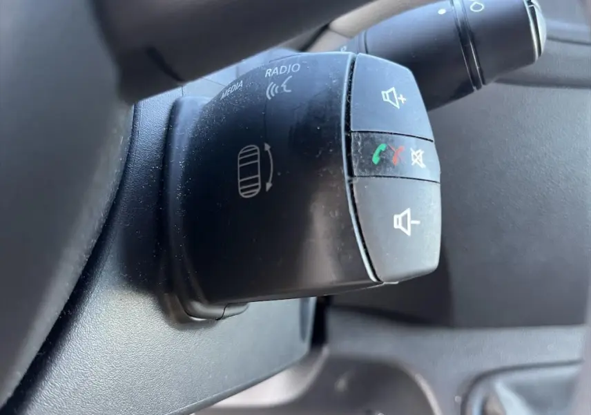 Gros plan sur la commande au volant du Renault Master blanc 2021, boutons pour volume et appels téléphoniques.