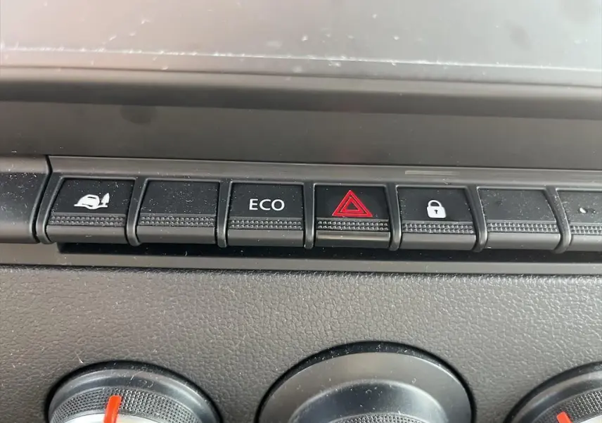 Gros plan sur les boutons de commande du tableau de bord du Renault Master blanc, avec bouton ECO et alerte triangle rouge.