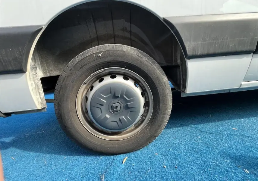 Gros plan sur la roue arrière gauche blanche du Renault Master 2.3 DCI 135 L2H3 avec enjoliveur Renault.