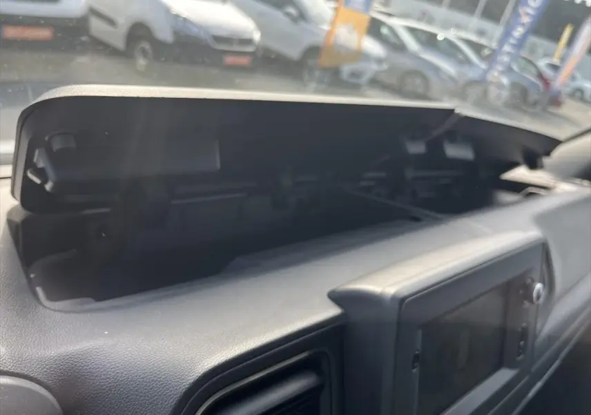 Vue rapprochée du compartiment de rangement ouvert sur le tableau de bord du Renault Master blanc de 2021.
