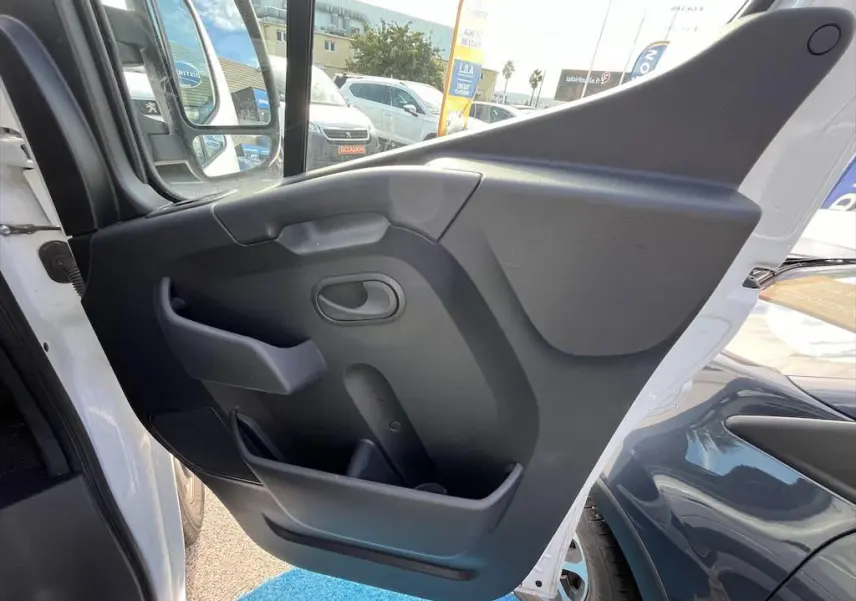 Vue rapprochée de la porte avant gauche blanche du Renault Master 2021, montrant la garniture intérieure noire.