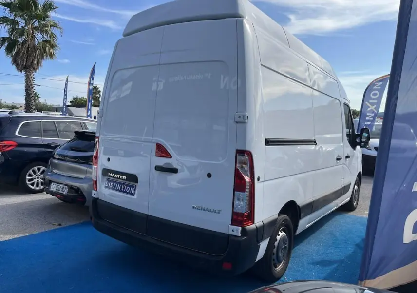 Renault Master blanc, vue 3/4 arrière droit, fourgon utilitaire avec toit surélevé sur parking extérieur.