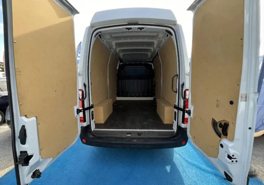 Vue arrière du Renault Master blanc 2021 avec portes ouvertes montrant l'espace de chargement vide et protégé par des panneaux en bois.