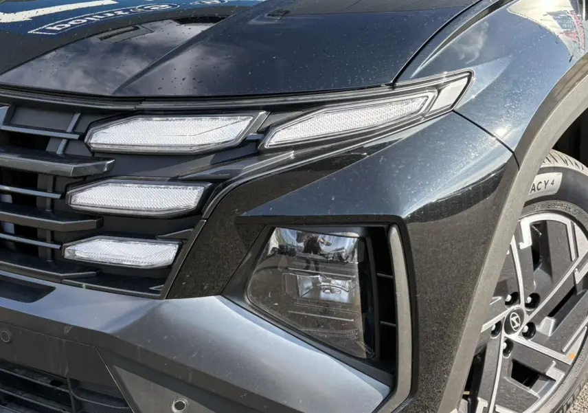 Gros plan sur l'avant droit du Hyundai Tucson Abyss Black 2025, mettant en valeur ses feux LED et jante alliage.
