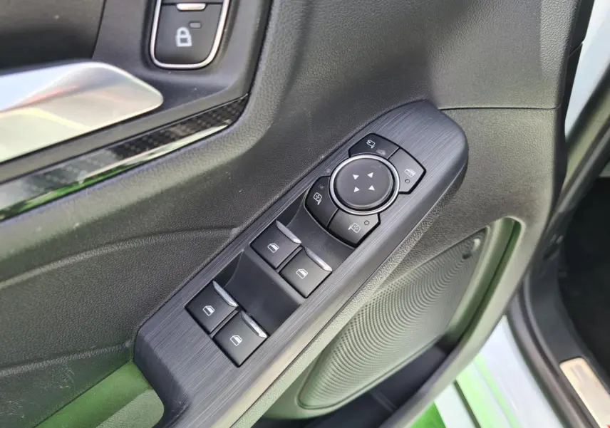 Gros plan sur les commandes de vitres et rétroviseurs côté conducteur du Ford Kuga blanc glacier 2022.