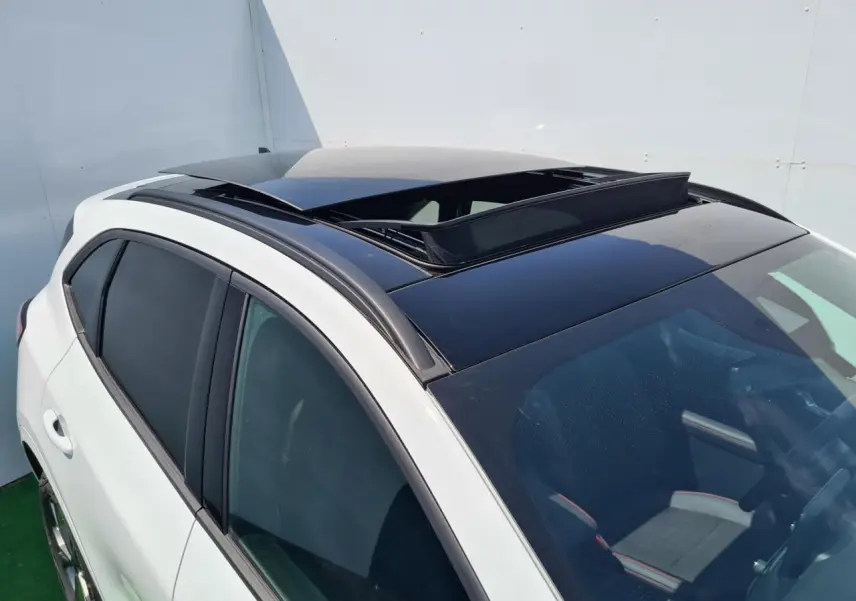 Vue 3/4 avant droit du Ford Kuga blanc glacier avec toit ouvrant panoramique ouvert et vitres surteintées.