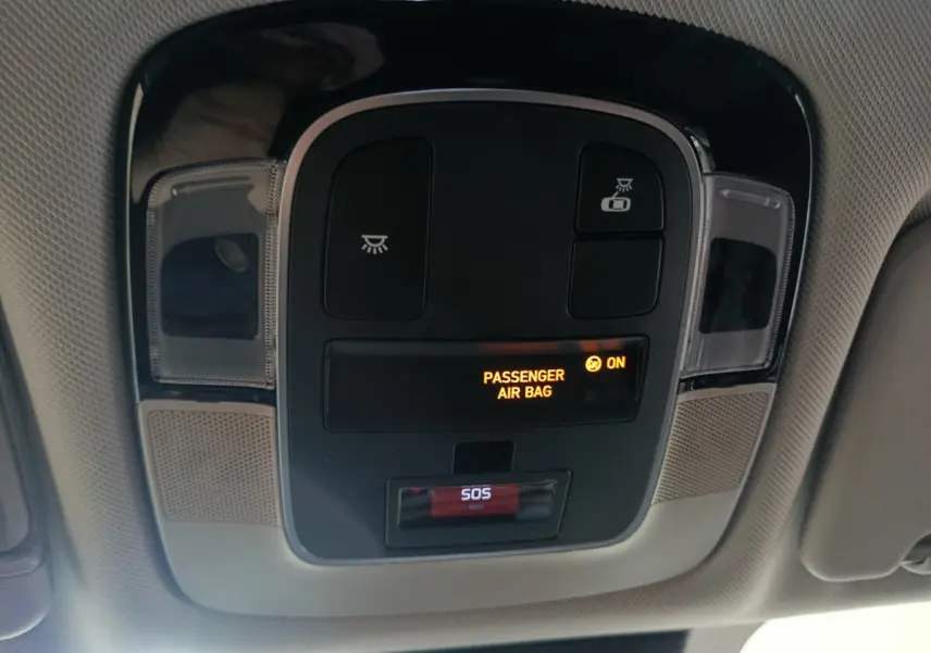 Vue intérieure en gros plan du panneau de contrôle au plafond avec indicateur airbag passager activé sur Hyundai Tucson gris foncé.
