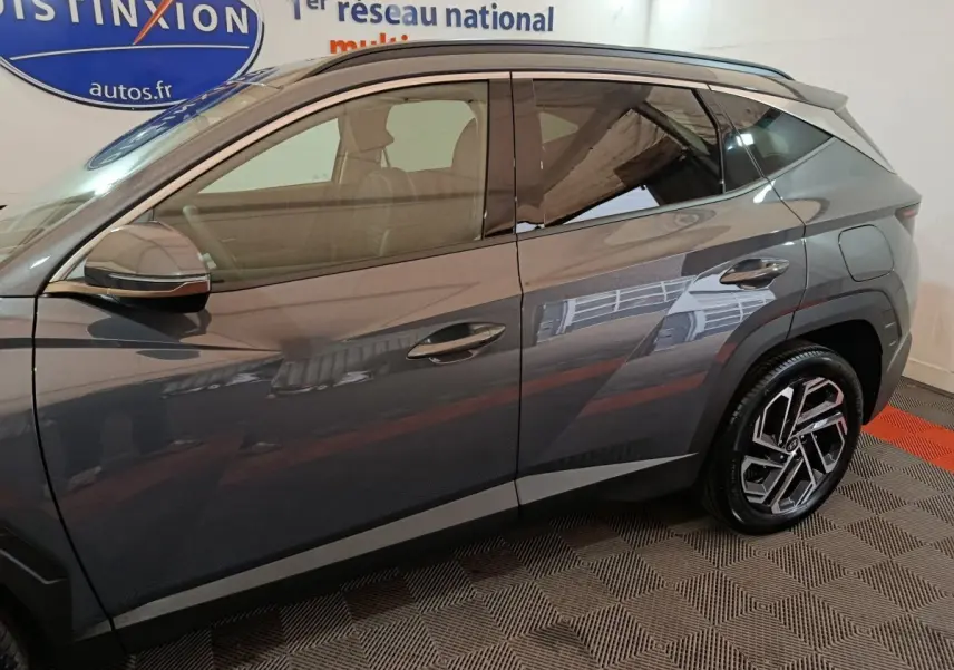 Vue de profil côté gauche du Hyundai Tucson 1.6 Hybrid 239 Creative Auto gris foncé avec jantes modernes en alliage.