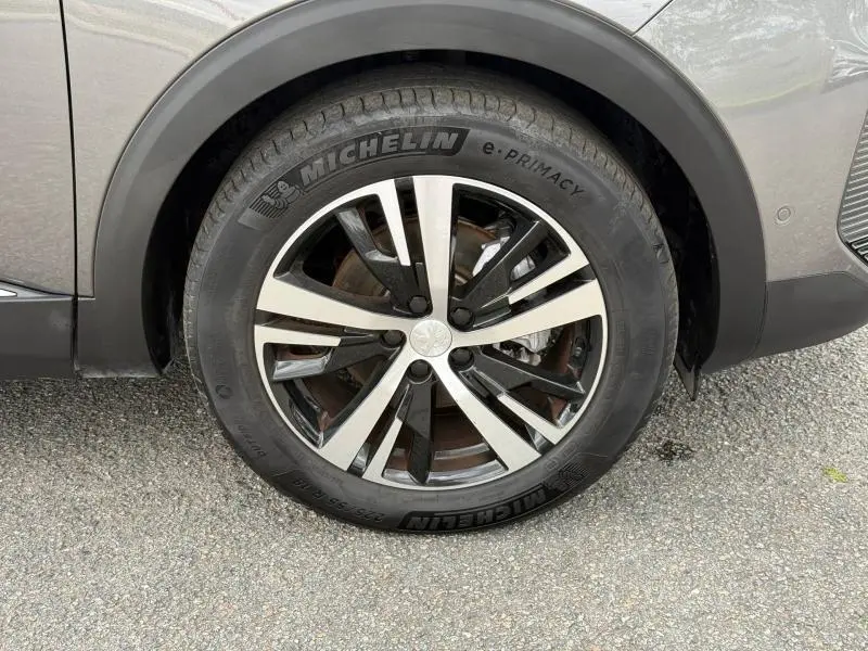 Gros plan sur la roue avant droite du Peugeot 3008 Gris Platinium avec jante alliage bicolore et pneu Michelin e-Primacy.