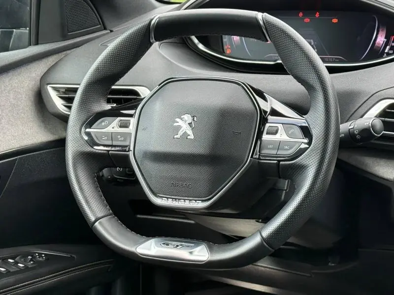 Vue rapprochée du volant cuir multifonction noir du Peugeot 3008 2024 avec logo et commandes intégrées.