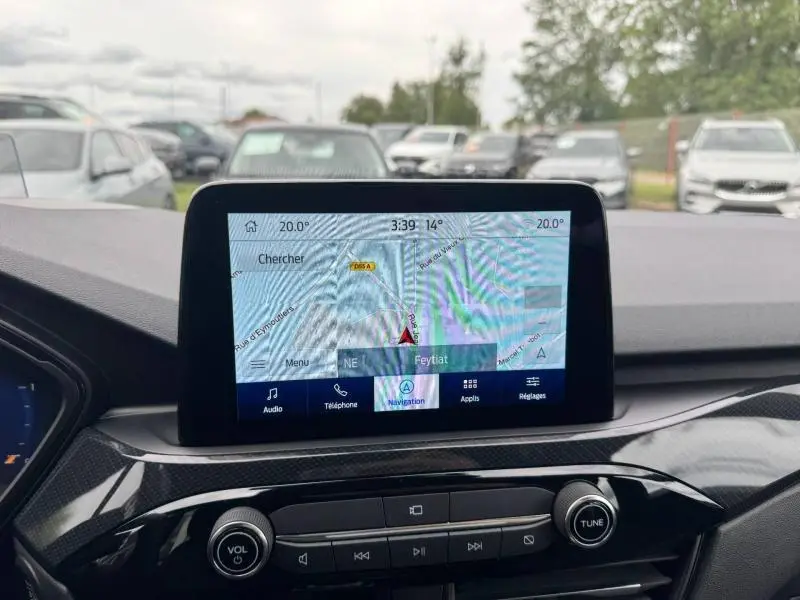Vue intérieure du tableau de bord du Ford Kuga 2023, écran tactile de navigation affichant une carte, finition noire brillante.