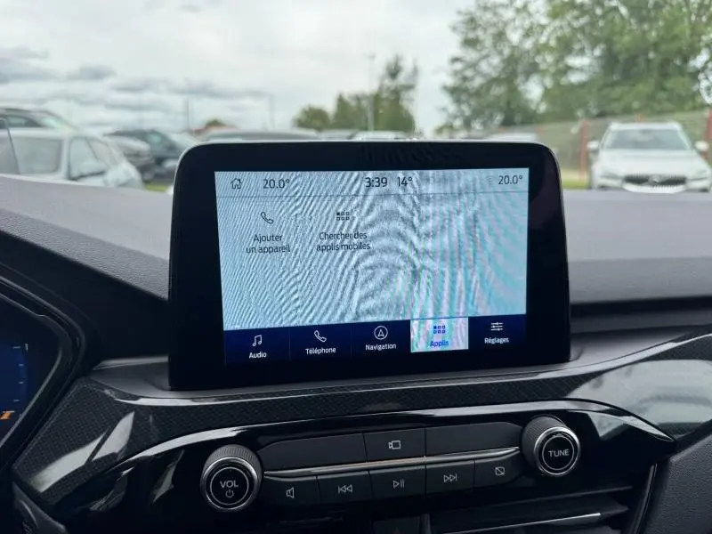 Vue rapprochée de l'écran tactile central et des commandes audio du Ford Kuga 2023, intérieur noir.