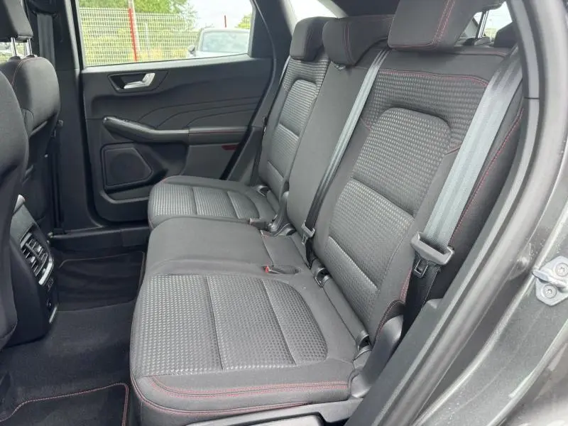 Vue latérale droite de la banquette arrière noire avec surpiqûres rouges du Ford Kuga 2023 gris Solar Métallisé.