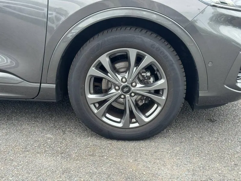 Gros plan sur la roue avant gauche du Ford Kuga gris Solar Métallisée, mettant en valeur la jante alu et le pneu Goodyear.