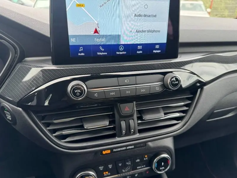 Vue rapprochée de la console centrale du Ford Kuga gris Solar, avec écran tactile et commandes audio intégrées.