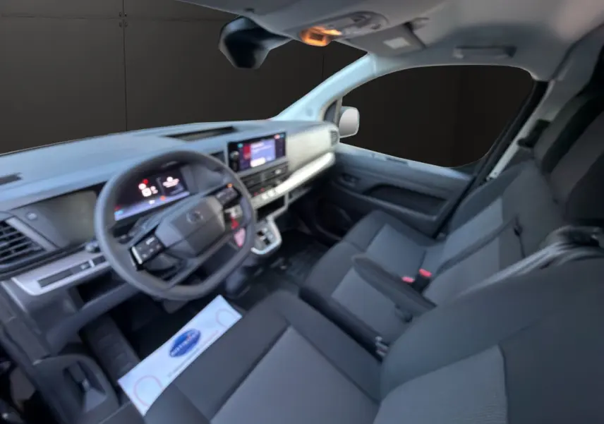 Vue intérieure côté conducteur du Citroën Jumpy 2026, montrant tableau de bord moderne et sièges noirs en tissu.