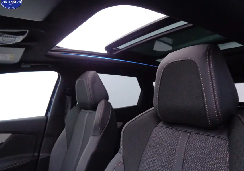 Intérieur du Peugeot 3008 2023 bleu Celebes, vue sur sièges avant en cuir noir et toit ouvrant panoramique.