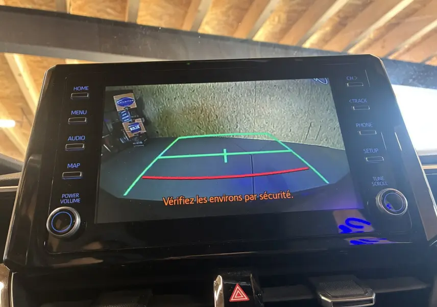 Écran tactile de la Toyota Corolla 1.8 122 Dynamic 2020 montrant la caméra de recul avec lignes de guidage colorées.