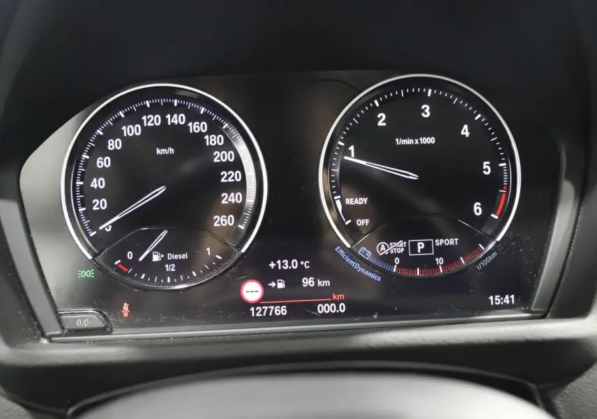 Vue rapprochée du tableau de bord numérique du BMW X1 sDrive 18D, affichant vitesse, régime et informations de conduite.