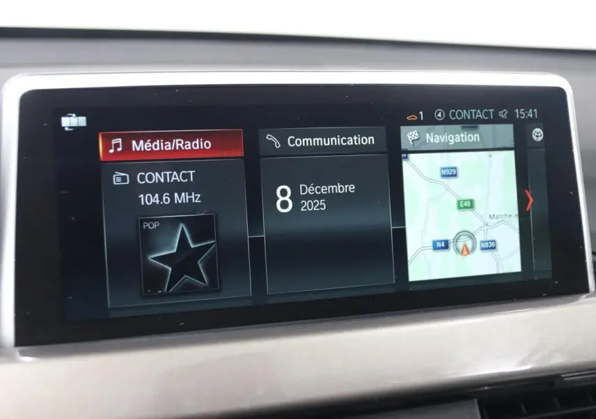 Écran central de la BMW X1 sDRIVE 18D 2019 montrant l'interface multimédia avec navigation et radio, vue intérieure.