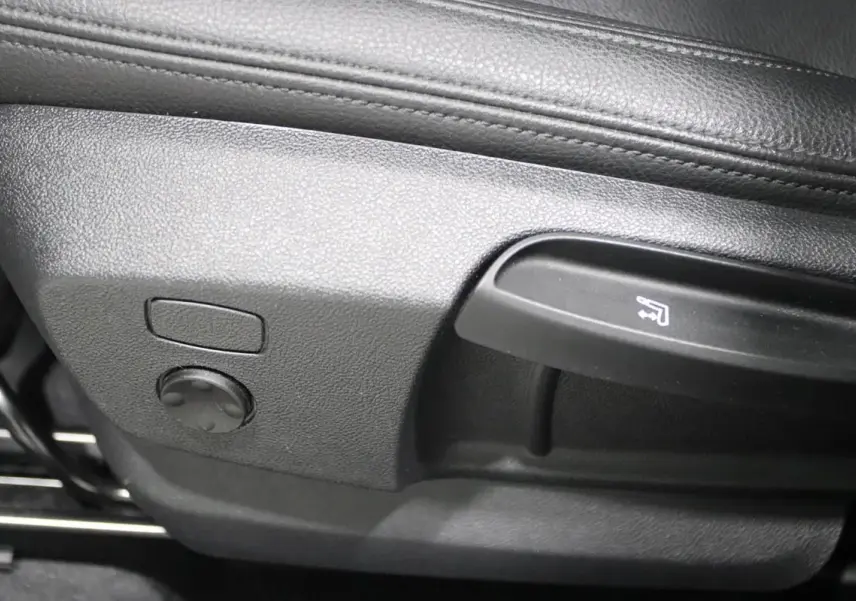 Détail des commandes de réglage du siège en cuir noir dans une BMW X1 sDrive 18D 2019.