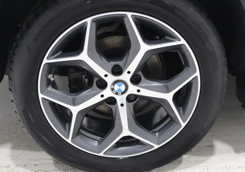 Gros plan sur la jante alliage bi-ton avec logo BMW au centre du BMW X1 sDRIVE 18D argent métallisé.