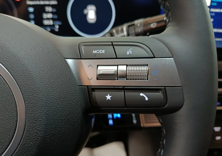 Gros plan sur les commandes multifonctions à droite du volant cuir noir du Hyundai Tucson gris clair 2025.